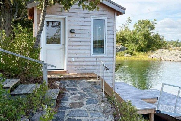 Wooden cabin with stone path and dock on waterfront