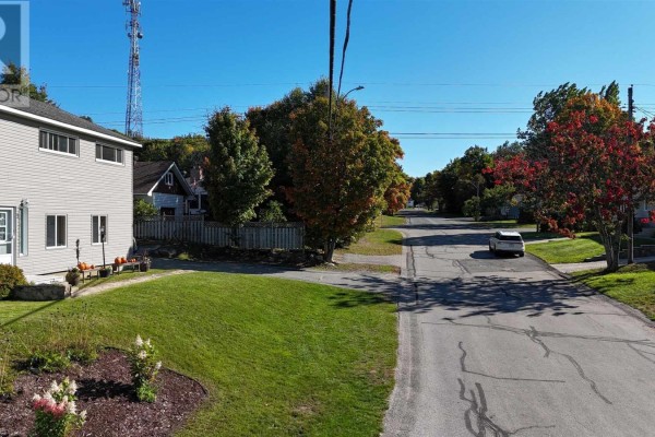 View down a paved street lined with trees and houses from the property. - 1 Joubin Rd, Elliot Lake