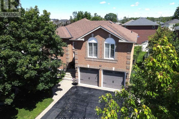 Aerial view of a two-story brick house with a double garage, surrounded by trees. - 1 Margaret Place, Georgina