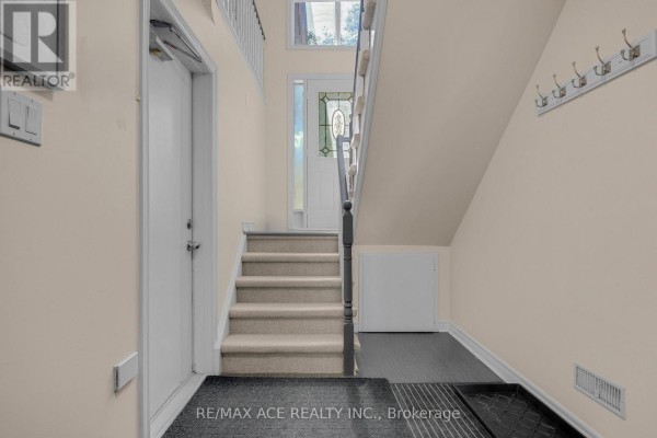 Interior view of a staircase leading up from the front entrance with carpeted steps. - 1 Margaret Place, Georgina