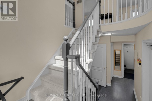 Interior view of a grand staircase with white spindles and beige carpet, leading to upper floors. - 1 Margaret Place, Georgina