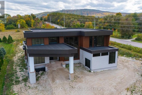 Unfinished landscaping surrounds the modern home with concrete and wood exterior. - 1 Meadowlark Way, Clearview