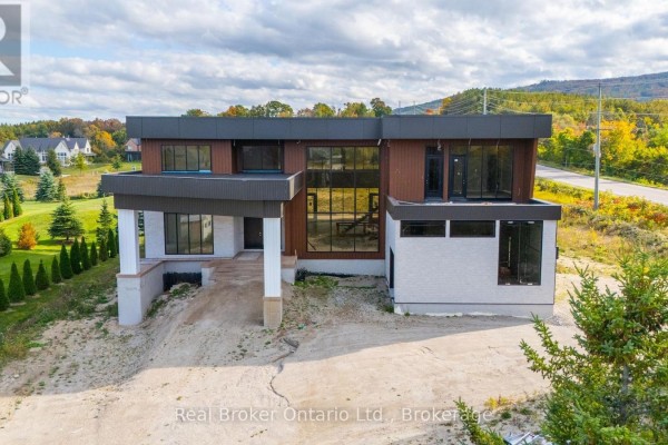Exterior of a modern concrete and wood home with unfinished surrounding grounds. - 1 Meadowlark Way, Clearview