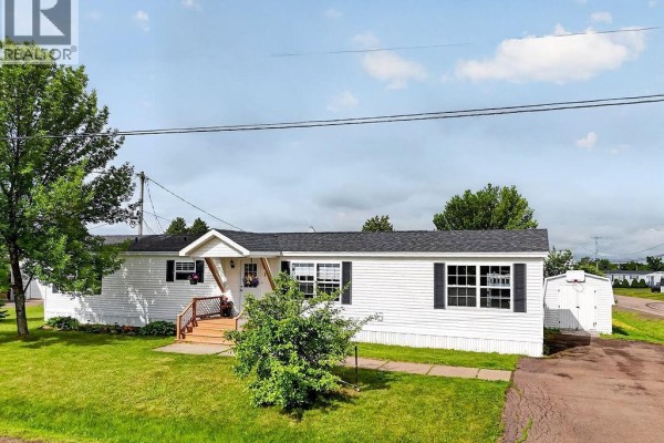 Side view of white modular home showing driveway and storage shed. - 1 Peridot, Moncton