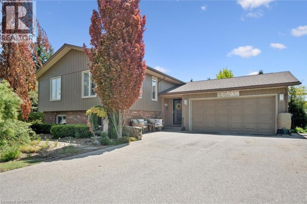Front view of the house entrance and garage with mature trees. - 1 Pintail Drive, Elmira