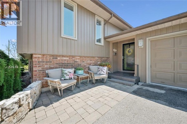 Paved patio seating area outside the front entrance next to the garage. - 1 Pintail Drive, Elmira