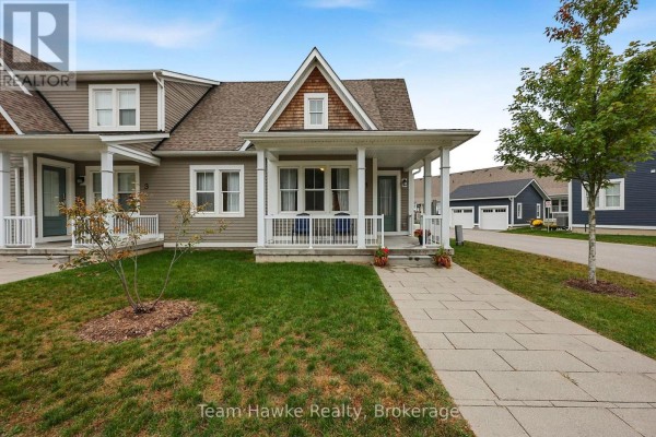Front view of a townhouse with a covered porch and green lawn. - 1 Samantha Lane, Midland