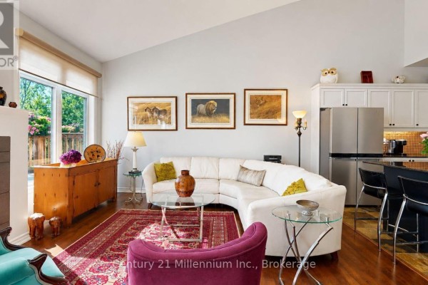 Living room with sectional sofa, kitchen island with stools, and artwork on wall. - 1 Sierra Trail, Collingwood