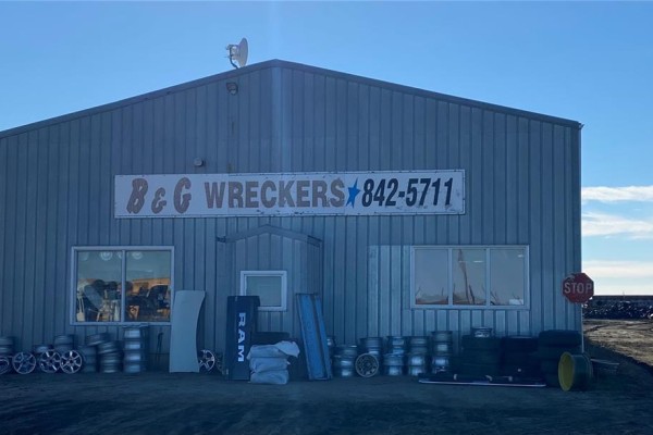 Exterior of a metal sided building with a sign reading "B & G WRECKERS" and various tires and car parts. - 1 Tindall Land, Brokenshell Rm No  68