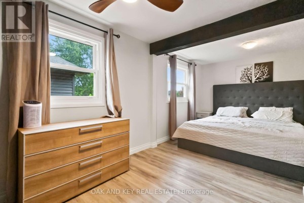 Bedroom with king bed, dresser, ceiling fan & exposed beam - 1 Vanier Place St Thomas