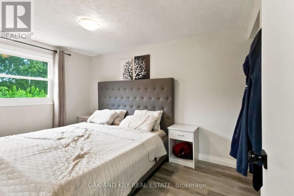 Bedroom with king-size bed, tufted headboard, and window - 1 Vanier Place St  Thomas