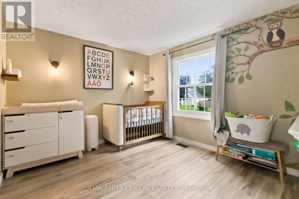 Nursery with crib, changing table, and tree mural - 1 Vanier Place St  Thomas