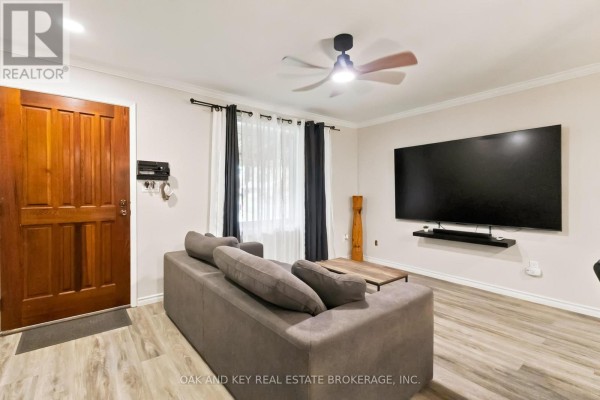 Living room showing sofa, sliding barn door, and stairs leading to an upper level. - 1 Vanier Place, St  Thomas