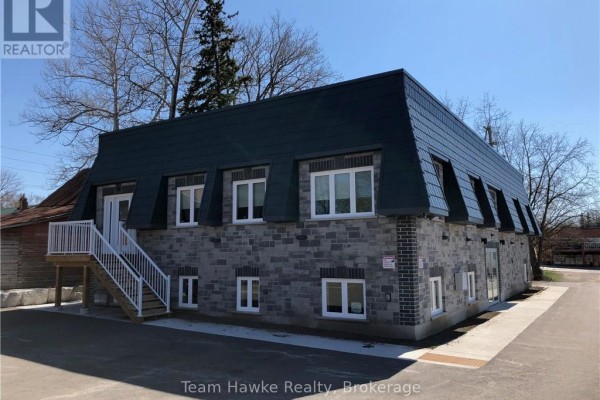 Two-story commercial building with stone facade and dark sloped roof, with an external staircase. - 1 West - 366 Midland Avenue, Midland