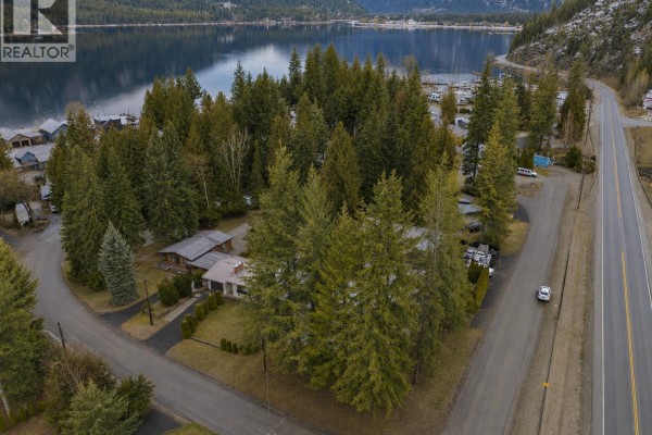 Aerial view of a mobile home community surrounded by trees and a lake. - 1 Wolfe Street, Sicamous