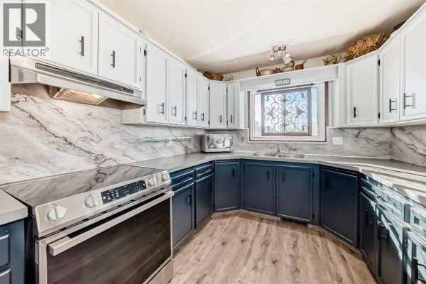 Interior view of a home entrance with a wooden ladder holding towels, a door, and rocking chairs. - 10, 1342 Township Road 361, Rural Red Deer County
