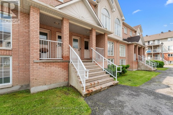 Entrance with brick facade, stairs, and white railings leading to the front door. - 10 - 1701 Blohm Drive, Ottawa