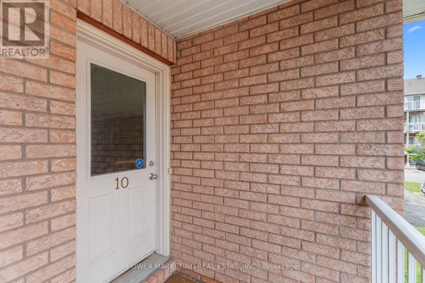 Front door view with a white door and brick wall. - 10 - 1701 Blohm Drive, Ottawa