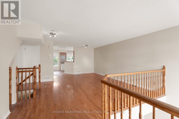 Spacious living area with hardwood flooring, neutral walls, and natural light from windows. - 10 - 1701 Blohm Drive, Ottawa