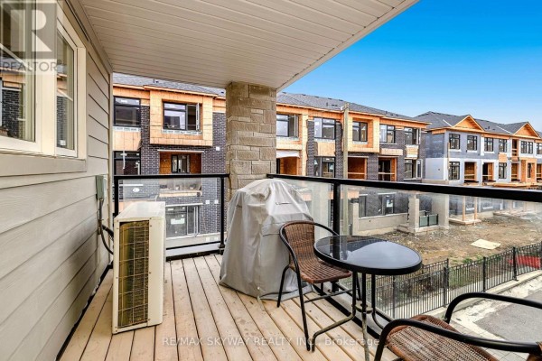 Wooden deck with glass railing, outdoor table, covered grill, and AC unit - 10 - 200 Veterans Drive Brampton