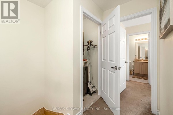 Hallway with closet, vanity, tile and carpet flooring - 10 - 200 Veterans Drive, Brampton