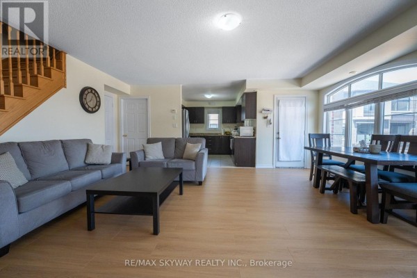 Open concept living, dining, and kitchen with wood floors, large window, stairs - 10 - 200 Veterans Drive, Brampton