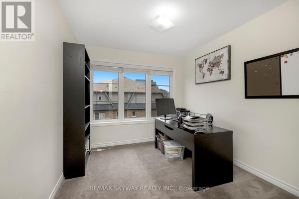 Office room with large window, carpet, desk, and bookshelf - 10 - 200 Veterans Drive, Brampton