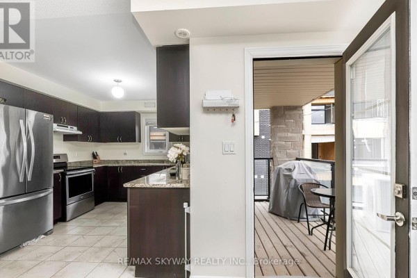 Modern kitchen with stainless appliances, granite counters, island, deck - 10 - 200 Veterans Drive Brampton