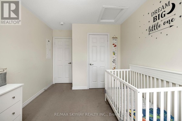 Bedroom with white crib, two doors, attic access - 10 - 200 Veterans Drive, Brampton