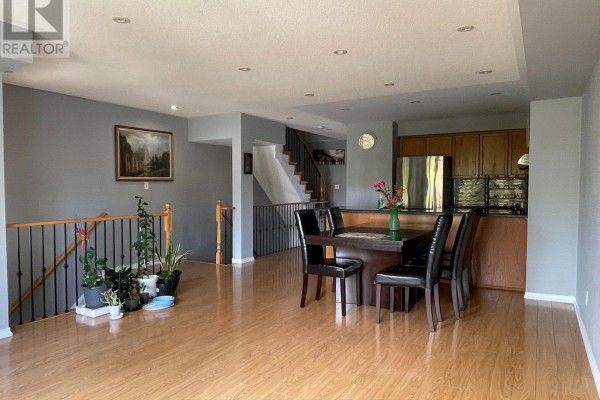 Interior view of a townhouse showing an open living area, dining space, kitchen, and staircase. - 10 - 3375 Thomas Street, Mississauga