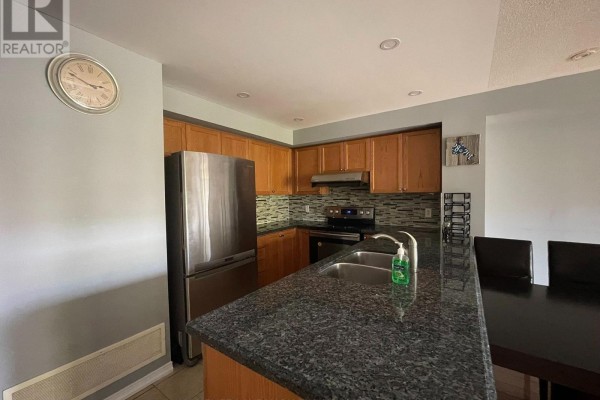 Kitchen features wood cabinets, granite countertops, stainless steel appliances, and a double sink. - 10 - 3375 Thomas Street, Mississauga