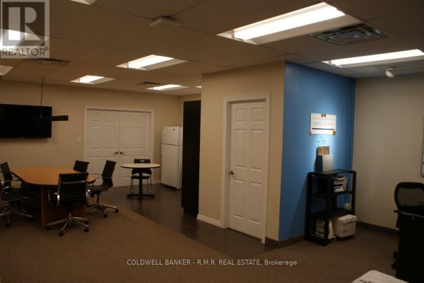 Office interior with conference table, chairs, separate round table, and white doors. - 10 - 500 Wentworth Street E, Oshawa