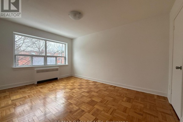Bright room with large window, hardwood flooring, and neutral walls - 10 - 69 Old Mill Terrace, Toronto