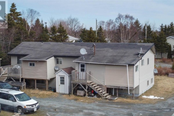 Rear view of a beige duplex showing multiple decks, stairs, and a small white shed. - 10-14 Effords Sub-division, Bay Roberts