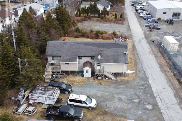 Aerial view showing the rear and side of the duplex, adjacent to a road and commercial buildings. - 10-14 Effords Sub-division, Bay Roberts