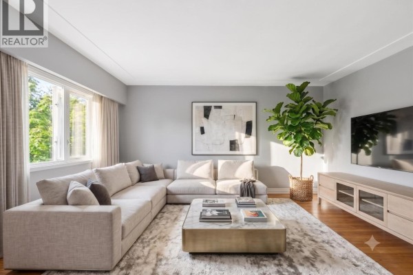 Living room with a large sectional sofa, marble coffee table, and a TV console. - 10 2296 W 39th Avenue, Vancouver