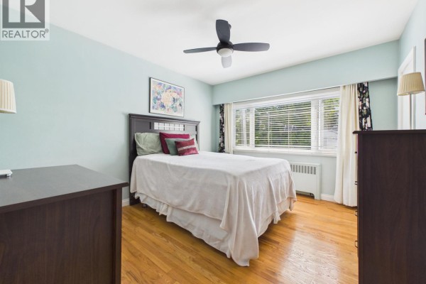 Bedroom with a queen bed, two dressers, a ceiling fan, and wood floors. - 10 2296 W 39th Avenue, Vancouver