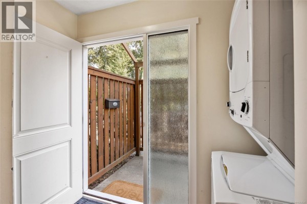 Close-up of a townhouse front door, white door, and adjacent small window. - 10 951 17th St, Courtenay