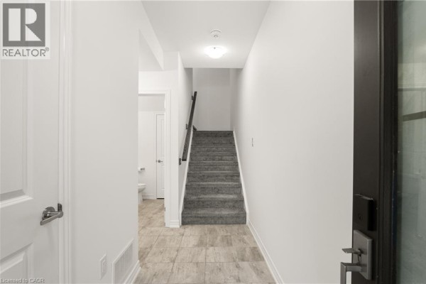 Balcony with seating area overlooking a street with parked cars. - 10 Birmingham Drive Unit# 129, Cambridge
