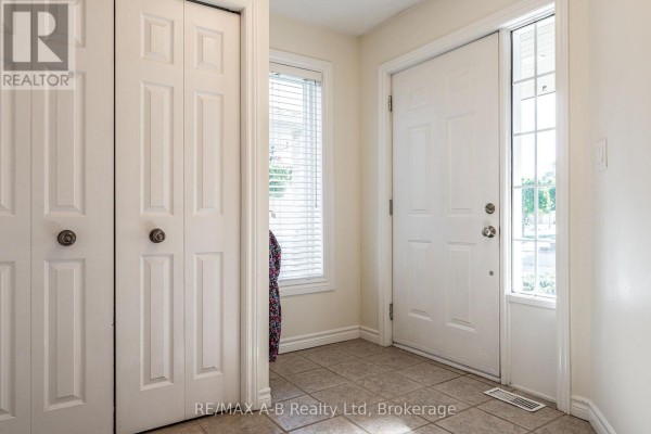 View of the front door, a window with blinds, and two bi-fold closet doors. - 10 Buckingham Drive, Stratford