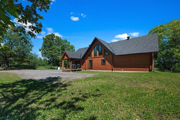 Dining area with wooden table and chairs, next to kitchen and view to exterior. - 10 Ch. Des Outaouais, L Ile Du Grand Calumet