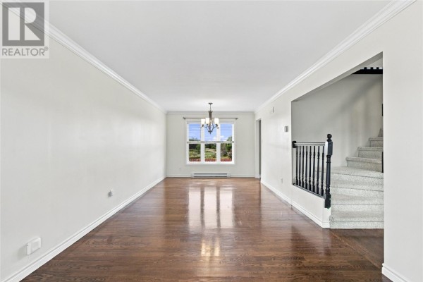 Empty living room with dark hardwood floors, white walls, and a chandelier. - 10 Clevedon Crescent, Paradise