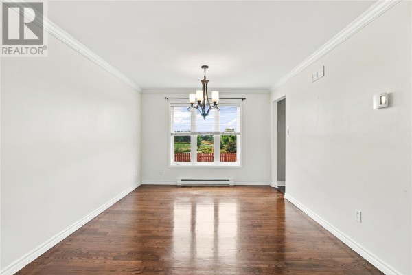 Empty dining room with dark hardwood floors, white walls, and a window view. - 10 Clevedon Crescent, Paradise