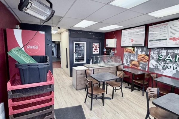 Interior view of sandwich shop with tables, chairs, counter, and food displays. - 10 Clinton Street, Toronto