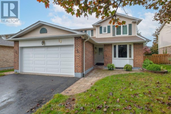 Front exterior of a two-story brick and vinyl house with a double garage door and driveway. - 10 Colette Drive, Whitby