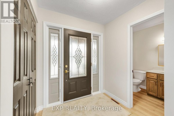 Entrance hallway with dark brown front door and adjacent closet. - 10 Donegel Place, Hamilton