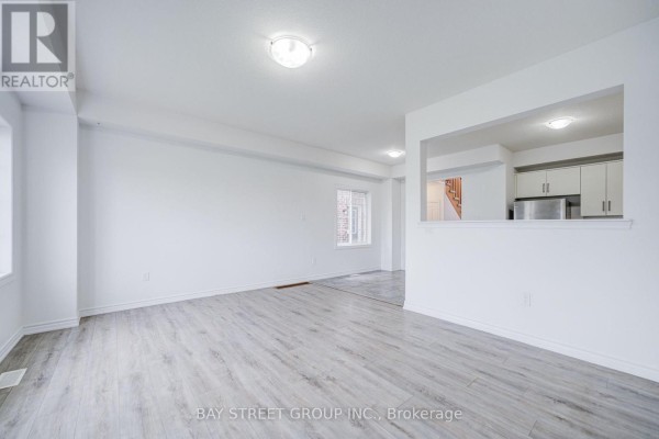 Living room with laminate flooring, glass door, and large window - 10 Elsegood Drive Guelph
