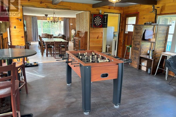 Interior recreation room with foosball table, dartboard, dining table, and wood-paneled walls. - 10 Fire Route 19 Route, Havelock Belmont Methuen