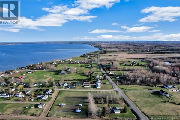 Aerial view of Cocagne waterfront with houses lining a coastal road and fields. - 10 Florina Street, Cocagne