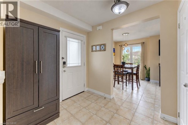 Interior view of an entryway with beige walls, tile floor, and dark cabinet. - 10 Foxglove Crescent Unit# 40, Kitchener